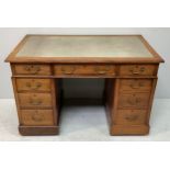 An early 20th century stained oak twin pedestal desk, with inset rexine scribe, original brass