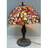 A reproduction Tiffany style table lamp with floral leaded glass shade and bronzed lilypad base,