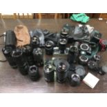 An Olympus OM10 camera with Super Travenar 1:2.8 lens, Canon EOS 100 carcass, various camera