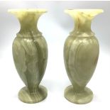 A pair of alabaster vases, of ovoid form, with flares rings and raised on circular, spreading foot