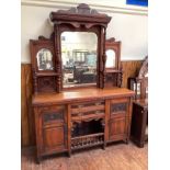 An Edwardian mirror backed sideboard made from walnut with ornate scrolled top pelmet, an oval