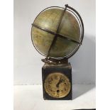 A late 19th / early 20th century German mechanical clock surmounted with a papier mache globe raised