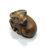 A Japanese Meji period hand carved boxwood netsuke of a Zodiac Oxen in recumbent pose facing