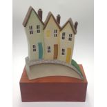 Paul Horton (contemporary) 'Homes & Hearts', painted resin sculpture of three houses on a sloped