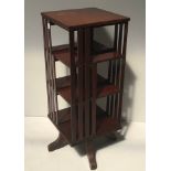 An early 20th century walnut revolving bookcase with three shelves on all four sides and slatted