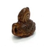 A Japanese Meji period hand carved boxwood netsuke of a toad surmounted with a snail and mites,