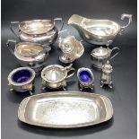 A small collection of assorted silver-plated items including a sauce boat, sugar bowl, open salts