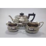 A late Victorian three-piece silver tea set, of compressed oblong 'Regency Style' with half-