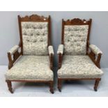 A pair of Edwardian carved walnut 'mother and father' parlour open armchairs with floral upholstery