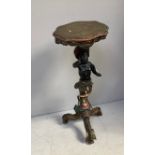 A carved and polychrome painted composition Blackamoor monopod torchere stand, with shaped top and