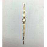 A ladies 9ct gold Rotary wristwatch with round champagne coloured face, batons denoting numbers,