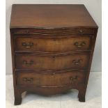 A mahogany serpentine chest of drawers with brushing slide over three shaped drawers, raised on