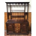 A mid-18th century oak dresser with dentil moulded cornice and open backed plate rack with shaped