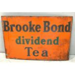 An enamel advertising sign 'Brooke Bond dividend Tea' with black letters to orange ground,