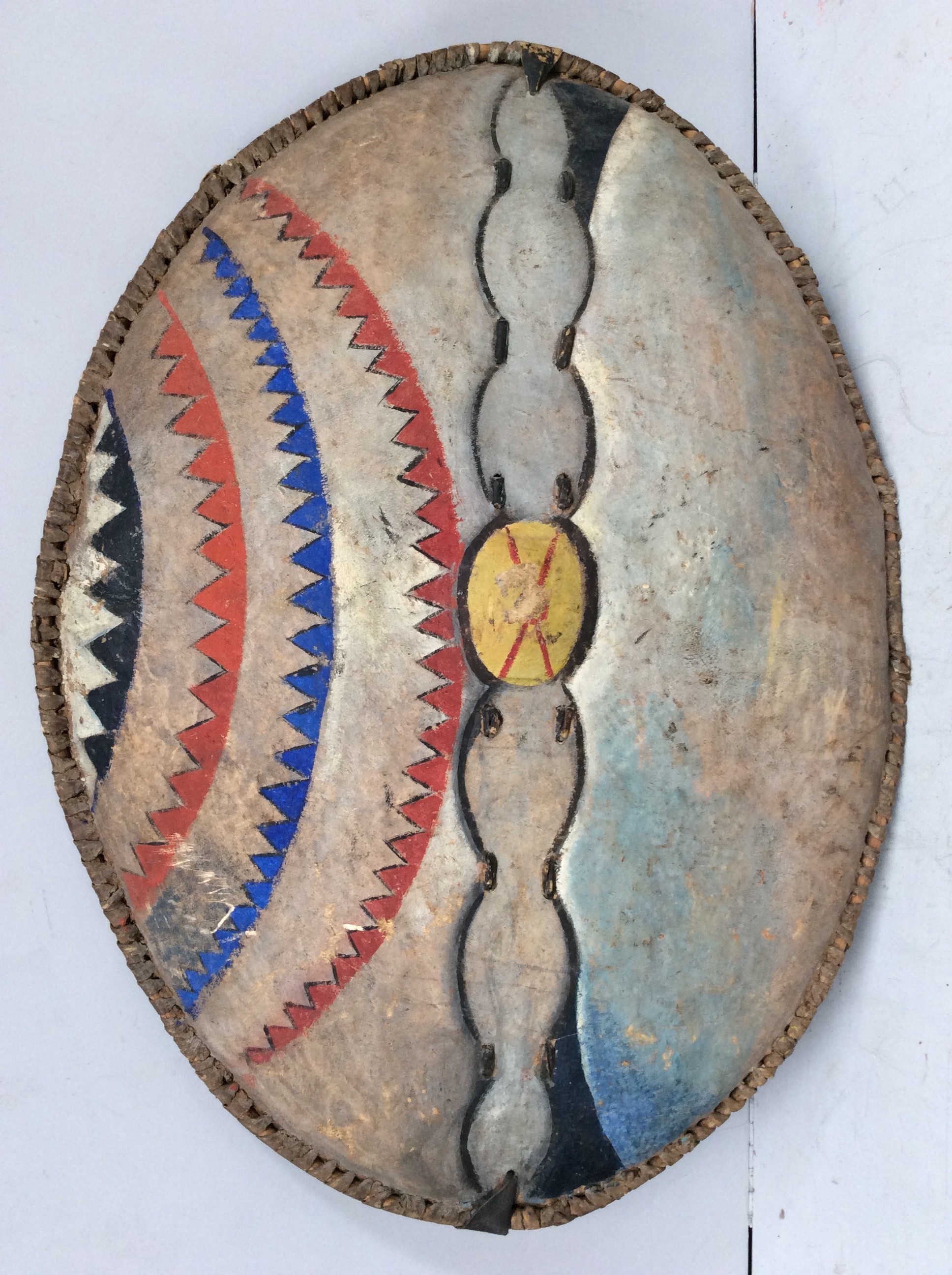 An unusual Maasai shield, Kenya, hide with painted with red, white, blue, black and yellow geometric