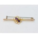 A yellow metal (tests as 9ct gold) spider bar brooch, set with two faceted amethysts to the head