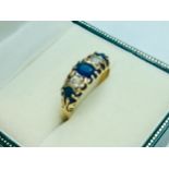 An 18ct yellow gold sapphire and diamond dress ring, set with three oval faceted sapphires and two