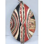 A mid 20th century Maasai shield, Kenya hide and painted with red, white, black and green