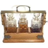 A metal bound wooden tantalus containing three cut glass decanters with globular stoppers (all