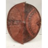 A Maasai shield Kenya hide with painted in earth red and black geometric decoration, with a wooden