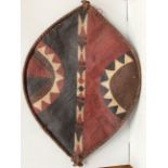 A large mid 20th century Maasai shield, Kenya hide painted with red, white and black geometric