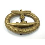 A German Third Reich WWII Kriegsmarine U-Boat submarine gilt badge, the U-Boat within oval wreath