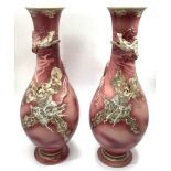 A pair of pink glazed Japanese pottery vases, decorated with relief moulded dragons wrapping
