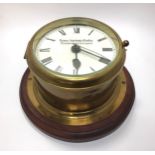 A brass cased ship's bulkhead clock with white enamel dial, black roman numerals, marked 'Thomas