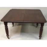 A Victorian mahogany dining table with turned and fluted supports on brass castors, 115cm in