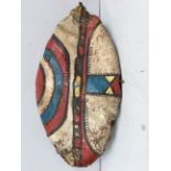 An early 20th century Maasai shield, Kenya hide with painted geometric decoration in bright red,