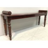 A Victorian mahogany window seat of narrow rectangular form with cylindrical capped ends on turned