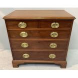 A 19th century mahogany chest of two short over three long graduated drawers with oval brass