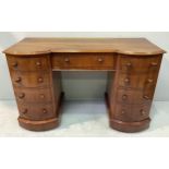 A Victorian mahogany inverted break-front kneehole desk with central drawer, flanked by two banks of