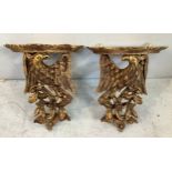 A pair of gilt composite wall brackets each modelled with an eagle perched on a branch with