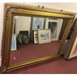 A very large gilt framed bevelled glass mirror carved with stylised spandrels, 147 x 118cm
