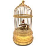 A 20th century singing bird automaton with gilt birdcage housing red and yellow birds amongst