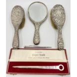 A pair of Victorian silver backed and handled brushes and a hand-held mirror embossed with putti and