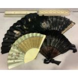 A large black lace fan hand-painted with a scene of three maidens picking flowers, with pink