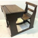 A large early 20th century stained oak school desk with inkwell and hinged scribe enclosing