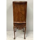 An early 20th century flame mahogany bow-fronted drinks cabinet, door opening to reveal shelves with