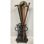 A cast iron small stick / umbrella stand, 53cm high, together with five various walking sticks