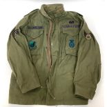 A green US Airforce flight jacket with applied badges for Pacific Air Forces, Sergeant arm patch and