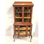 An Edwardian two-tier, two door display cabinet with cross-banding and caddy top, lattice-glazed