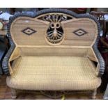 A wicker conservatory sofa finished in a two colour lattice work with a decorative oval back 140cm