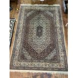 A hand knotted carpet with central brown and blue medallion to cream ground with outer borders of