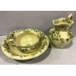 A three-piece Ironstone pottery wash set comprising chamber pot, wash basin and jug, all with floral