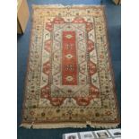 A traditional hand made geometric oriental wool rug with a central oblong design and patterned