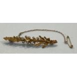 A 15ct gold bar brooch modelled as leaves, interspersed with seed pearls, the back stamped with a
