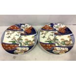 A pair of Japanese Meiji period Imari porcelain chargers decorated with birds amidst trees in