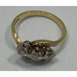 An 18ct gold three-stone diamond ring, cross-over style, round brilliant cut, claw-set, estimated